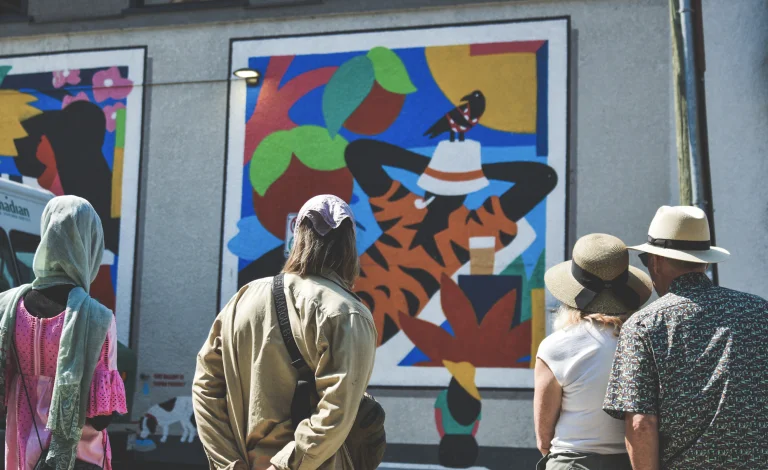 four people looking at a colourful mural on a west end laneway in Vancouver